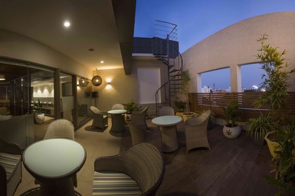 Mint N Mustard Rooftop Restaurant at Mayberry Tiruppur with an open roof with plants and a relaxed dining atmosphere